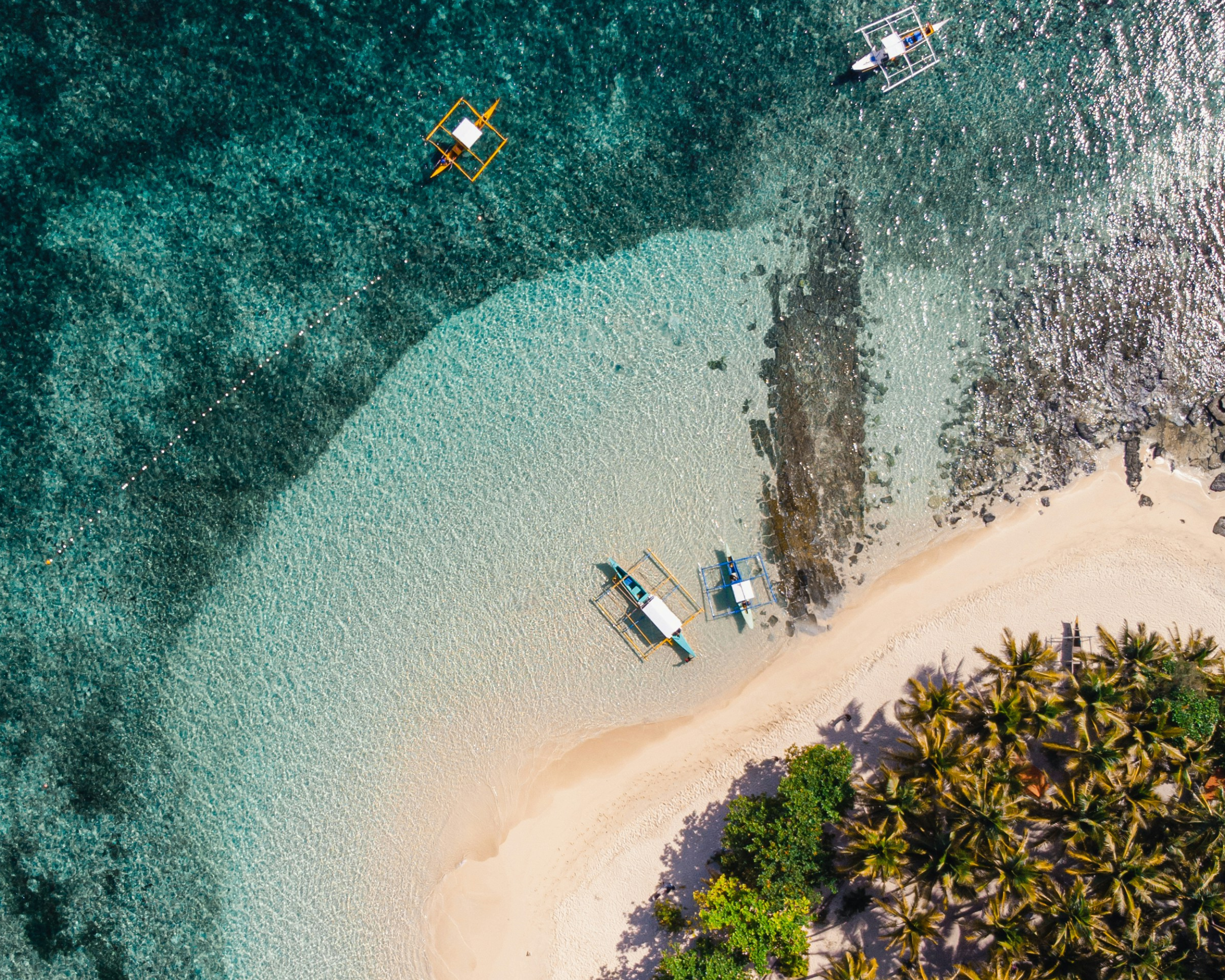 A Philippine island community beneath a forested limestone landscape