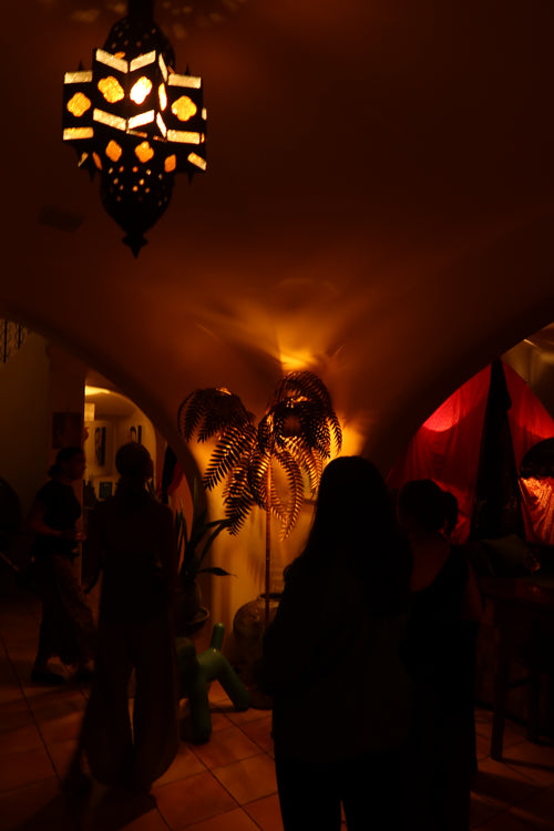 Guests moving through a warmly lit creative home during Creativity, Lived. Photo courtesy of With Meraki Travel Collection.