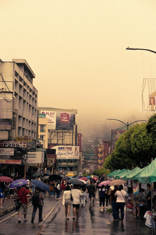 People walking under umbrellas on Session Road in Baguio, Philippines. Photo: Jayson Lagman / Unsplash.
